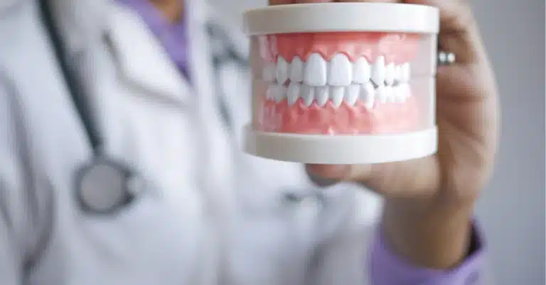 Dental professional holding denture model showing how modern dentures have come a long way with advanced technology and natural appearance