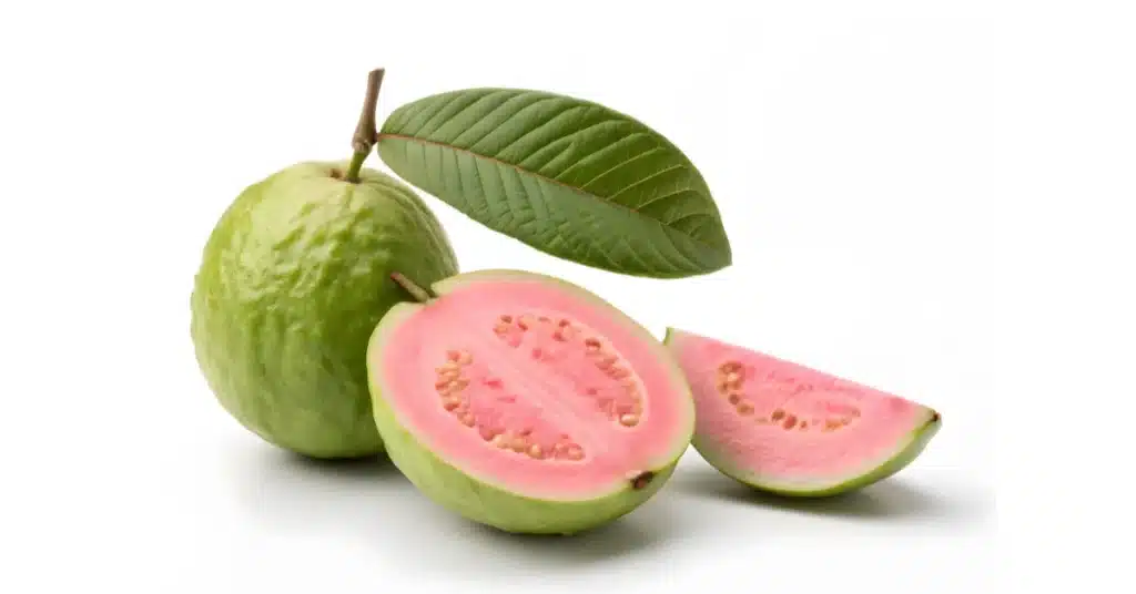 Ripe guava fruit with green skin and pink flesh, shown whole and sliced, with green leaves on a white background.