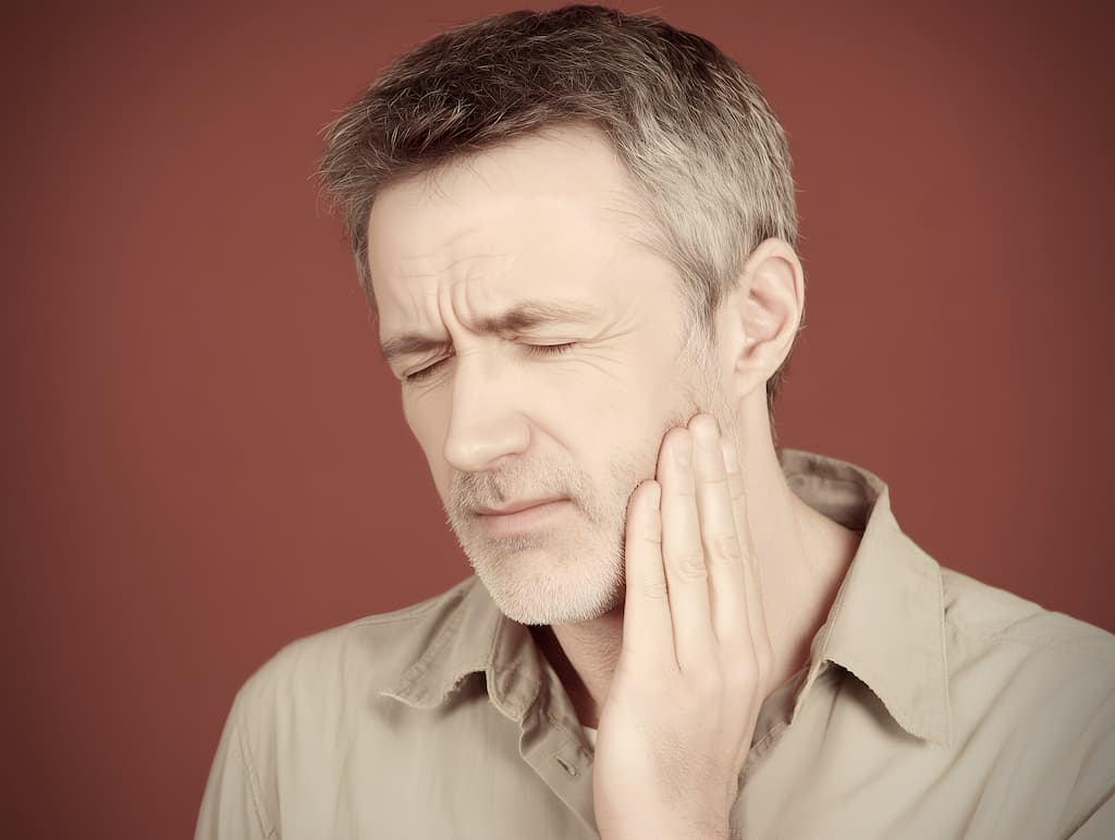 A man with pain from tooth sensitivity.